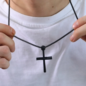 Close-up of black punk cross pendant necklace in tactical industrial style on a model