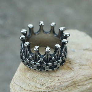 Macro view of retro crown ring featuring detailed cross embossing and gothic punk style