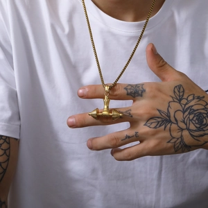 Detail of a golden dumbbell pendant necklace on a box chain for fitness style