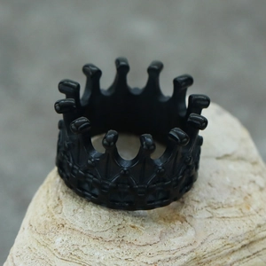 Macro detail of black Gothic crown ring with matte finish and textured steel pattern