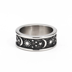 Gros plan d'une bague rétro en acier titane avec motifs soleil, lune et étoiles gravés