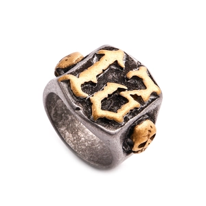 Detailansicht eines Vintage Punk-Rings mit goldenen G-B-Buchstaben und Totenkopfrelief