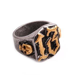 Detail eines Vintage-Punk-Rings mit goldenen Totenköpfen und Nummer 13 auf quadratischem Kopf