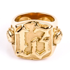 Detailansicht eines goldenen Punk-Rings mit Nummer 13 und seitlichen Totenköpfen