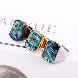 Detail of square titanium steel rings with iridescent abalone shell inlays in 3 colors