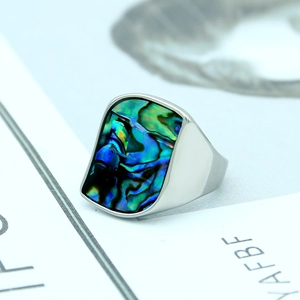 Macro shot of silver titanium steel ring featuring colorful inlaid abalone shell patterns