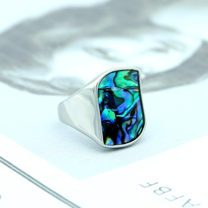 Macro view of wide titanium steel ring with colorful abalone shell inlay on magazine