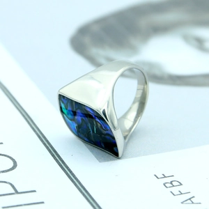 Macro view of geometric titanium ring with square colorful iridescent abalone shell inlay