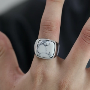 Gros plan détaillé d'une bague de type chevalière pour homme avec pierre de marbre