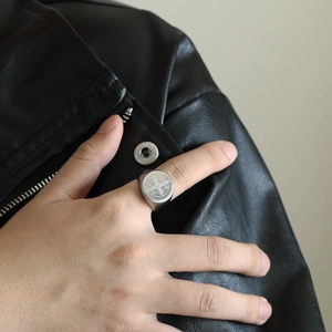 Makroansicht des silbernen Benediktus-Siegelrings mit religiösem Kreuzrelief auf Stahl