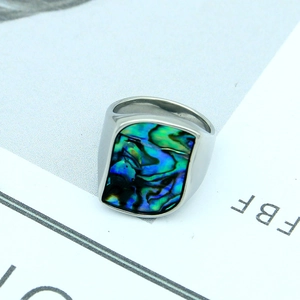 Macro shot of geometric titanium steel ring with iridescent abalone shell inlay detail