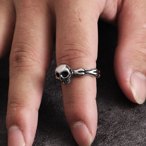 Anillo de calavera vintage en acero de titanio oxidado usado en la mano