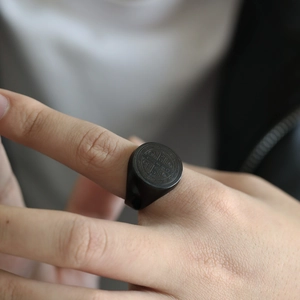 Nahaufnahme eines schwarzen Benediktus-Siegelrings aus Edelstahl am Finger