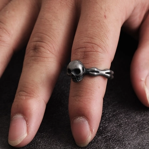 Primer plano de un anillo de calavera vintage con estructura ósea detallada al dedo