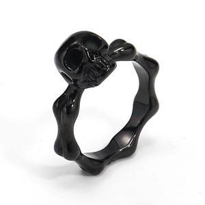 Detalle de anillo punk de acero inoxidable negro con calavera y huesos cruzados