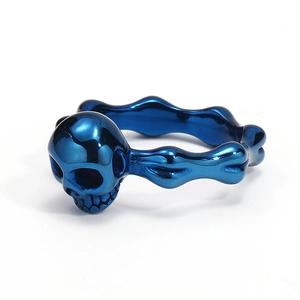 Vista detallada de anillo de calavera con banda esquelética en azul metalizado