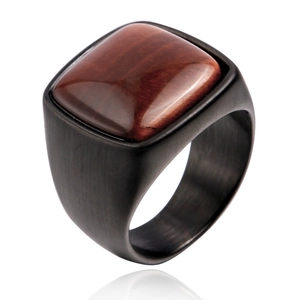 Gros plan de bague rétro pour hommes avec œil de tigre rouge et anneau en acier noir mat