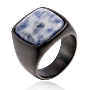 Détail d'une bague en titane noir mat montrant une grande pierre bleue carrée texturée