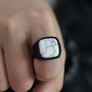 Gros plan d'une bague rétro en acier titane avec pierre de marbre carrée pour homme