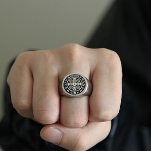 Detail eines Vintage-Siegelrings mit Benediktuskreuz aus mattem Silberstahl am Finger