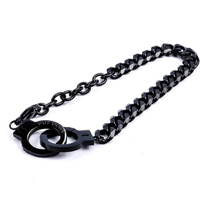 Detail of black Cuban link bracelet with a 'PUT DOWN' engraved handcuff charm