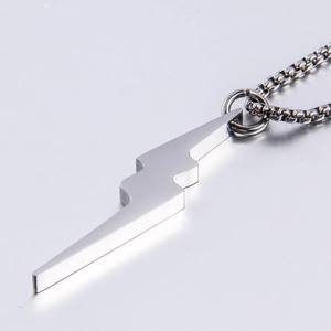Macro side view of polished lightning bolt pendant with thick stainless steel box chain