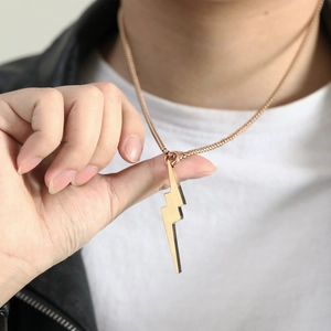 Close-up of a 3D rose gold lightning bolt pendant on a chain for a modern urban look