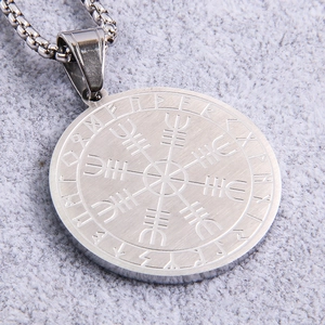 Close-up of a Viking Vegvisir compass pendant with Nordic runes on brushed stainless steel