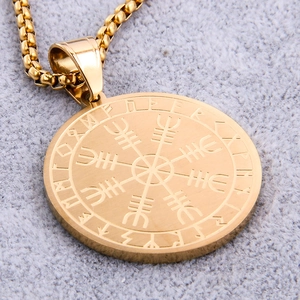 Macro shot of gold stainless steel Viking Vegvisir compass pendant with Rune engravings