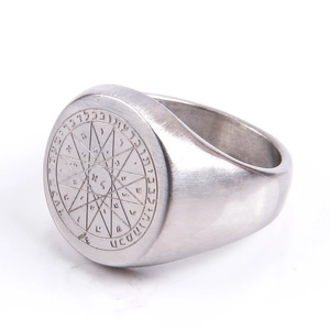 Detail of vintage stainless steel compass signet ring with engraved mystic symbols