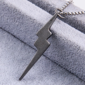 Macro detail of lightning bolt pendant with industrial square chain in vintage grey steel