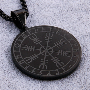 Macro shot of Viking compass necklace in matte black stainless steel with runic engraving
