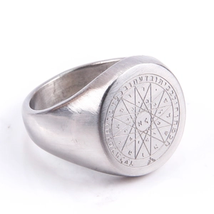 Close-up of matte brushed stainless steel signet ring with compass and rune engravings