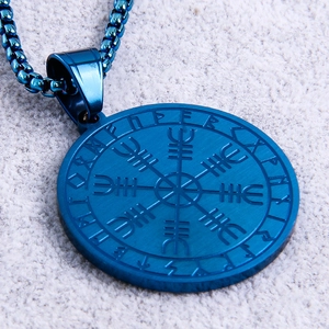 Macro shot of blue Viking Vegvisir compass pendant with Nordic runes on stainless steel