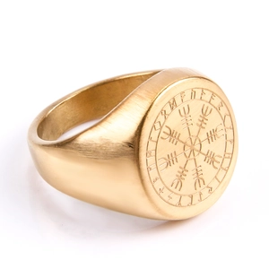 Gros plan détaillé d'une bague boussole viking dorée avec runes gravées sur métal brossé