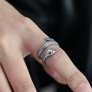 Macro view of iridescent snake ring showing detailed scales and adjustable open band design