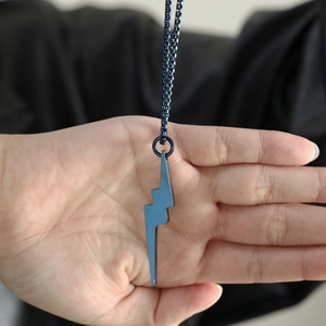 Detailed view of matte dark blue lightning bolt pendant on a square box chain