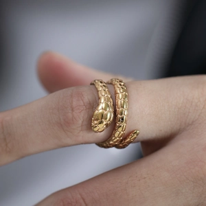 Detailed close-up of golden stainless steel snake ring showing intricate scale texture on finger