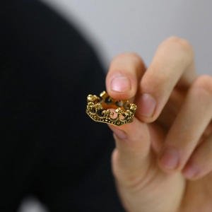 Detailed close-up of retro stainless steel crown ring with intricate hollow engraving