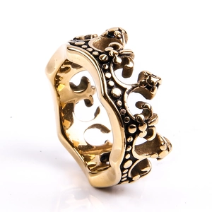 Macro detail of vintage gold crown ring featuring embossed dots and punk style textures