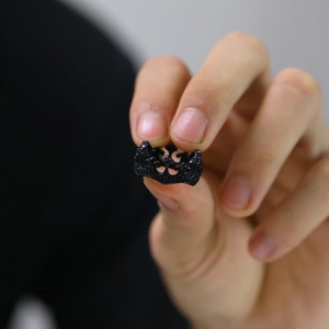 Detail of vintage matte black stainless steel crown ring featuring hollowed-out punk design