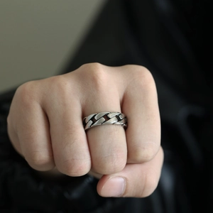 Close-up of a silver polished stainless steel Cuban link ring worn on a finger