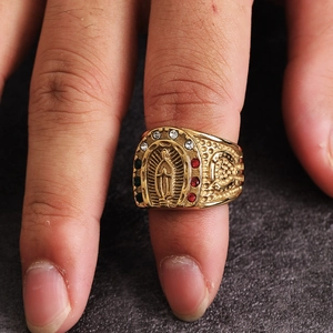 Macro shot of horseshoe-shaped gold ring with Virgin Mary relief and colorful crystals