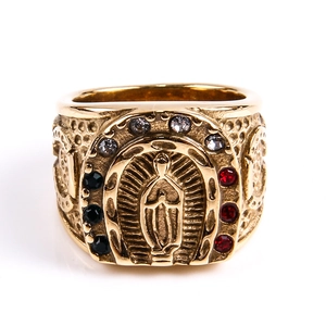 Detail of vintage gold religious ring with Virgin Mary relief and colorful rhinestones