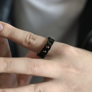 Close-up of black stainless steel curb chain ring on model hand with industrial style