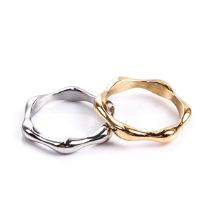 Detail von wellenförmigen Edelstahlringen in polierter Gold- und Silberoptik