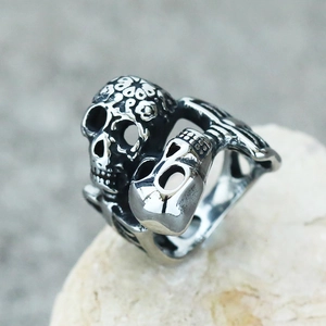 Gothic punk dual skull ring in vintage stainless steel on a natural stone display