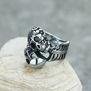 Macro shot of punk double skull ring with rib bone texture on a natural stone base