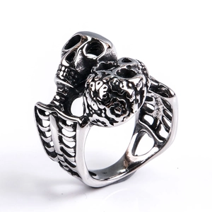 Close-up of gothic stainless steel double skull ring with detailed rib cage band