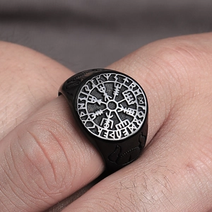 Macro detail of matte black Viking compass ring with carved runes and Norse patterns